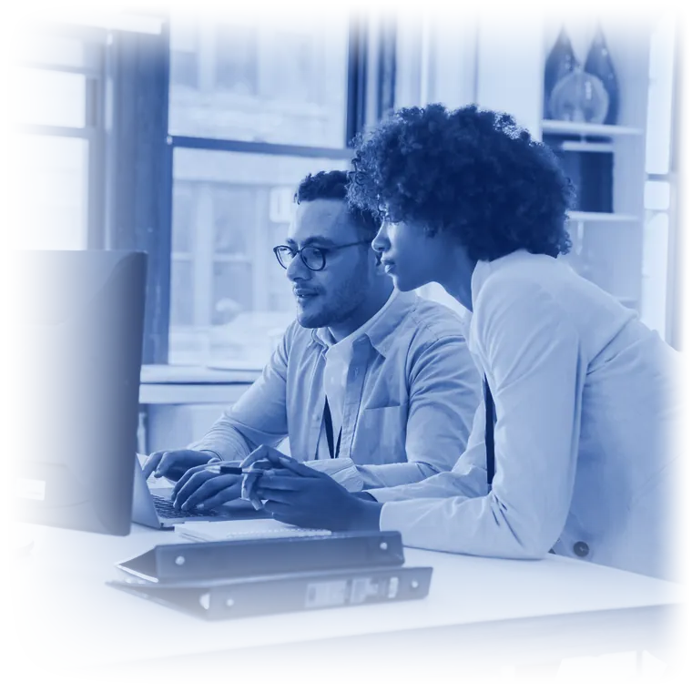 Two colleagues working together at a computer in a bright office